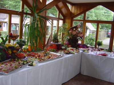 Ein Buffet-Tisch mit viel Essen in einem Raum mit vielen Fenstern.